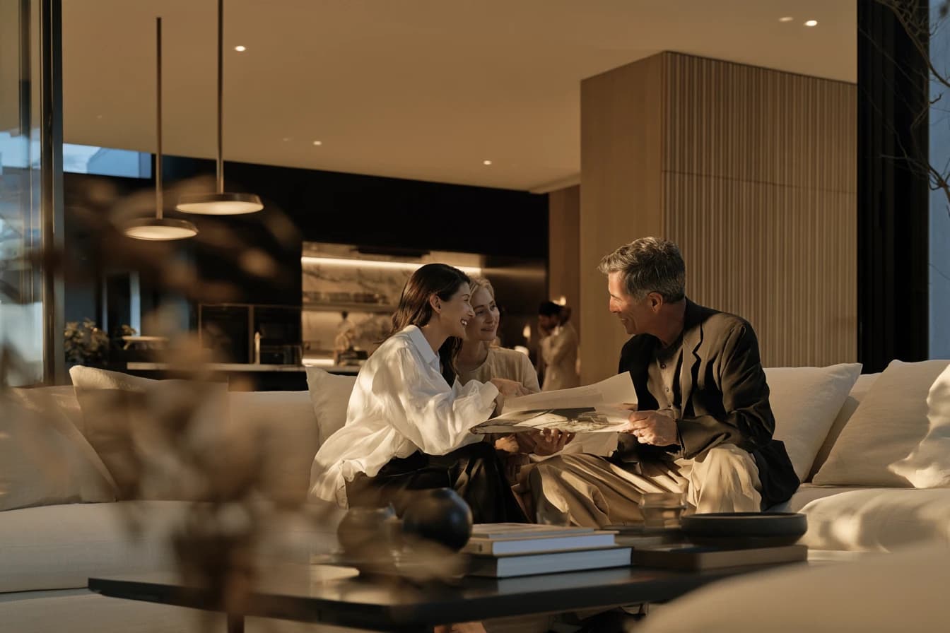 Three people on a sofa in the evening, going through papers together