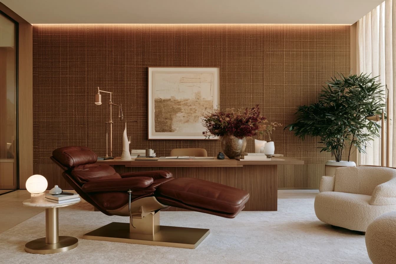A consulting room with a leather treatment chair and a walnut desk