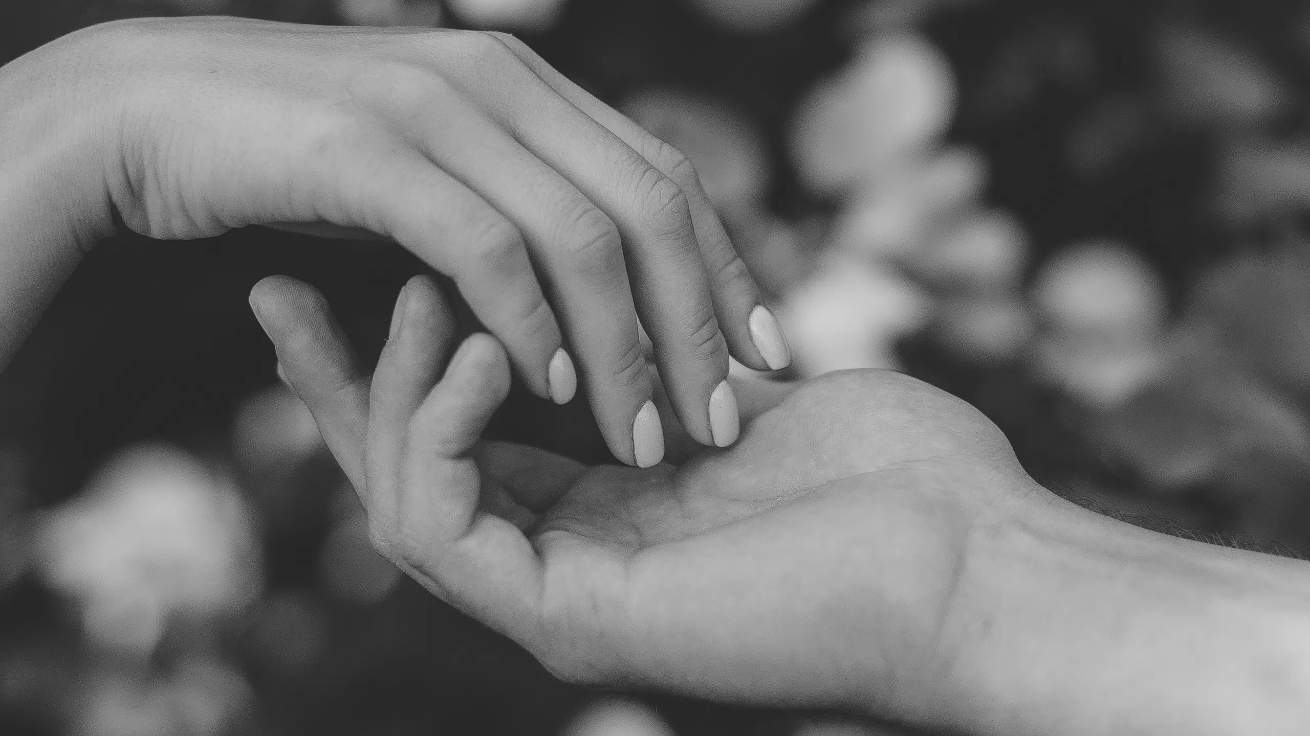 Two hands almost touching, in black and white