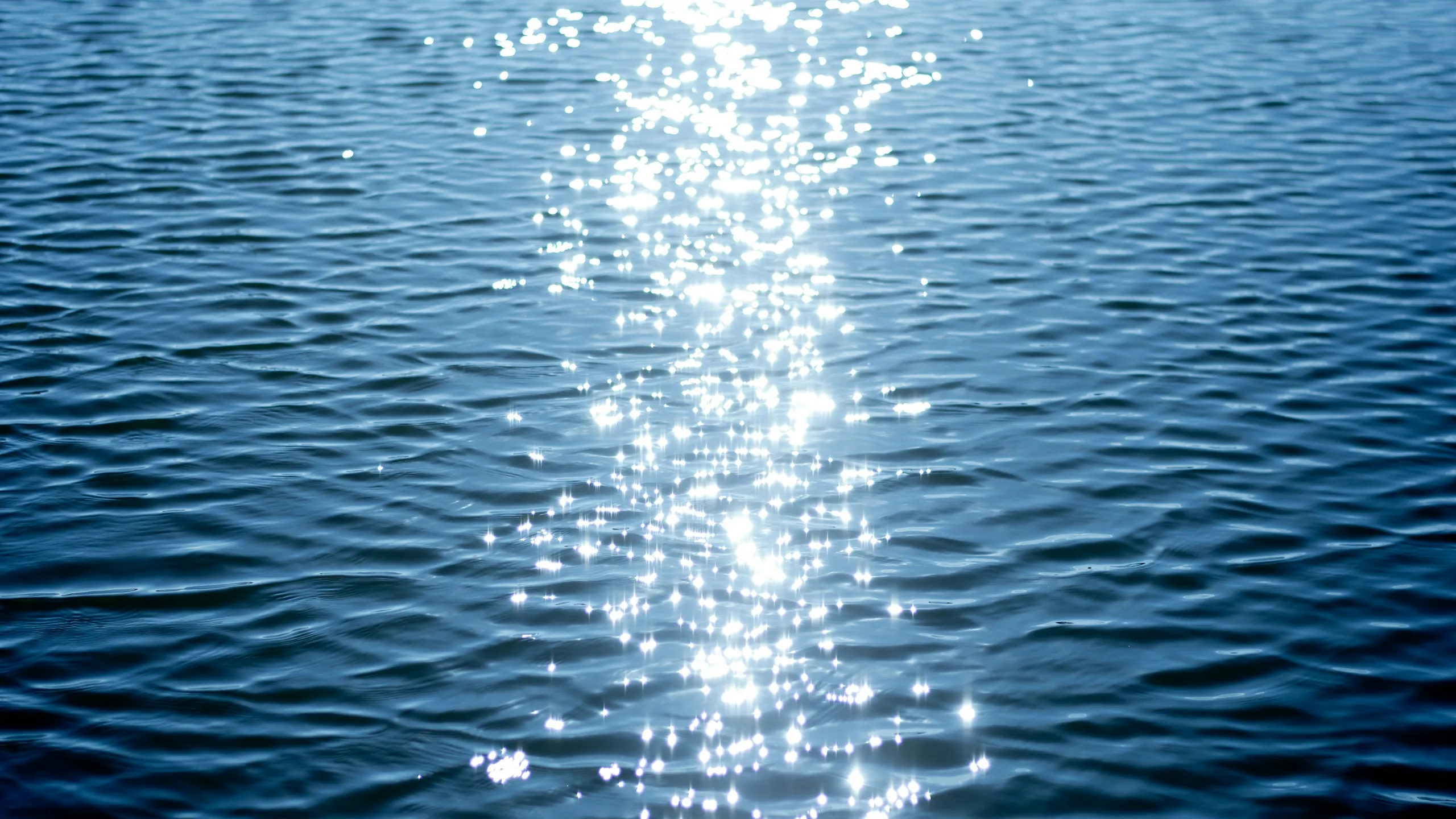 A path of sunlight glittering on deep blue water