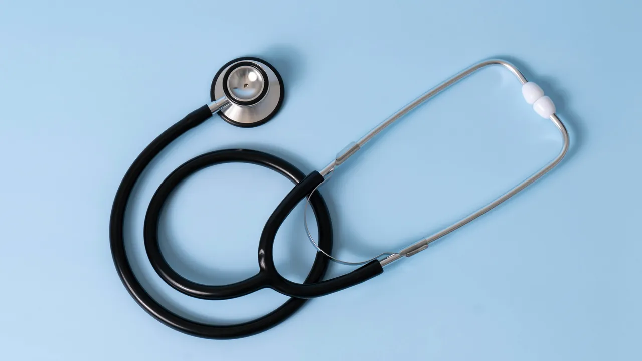 A stethoscope resting on a pale blue surface