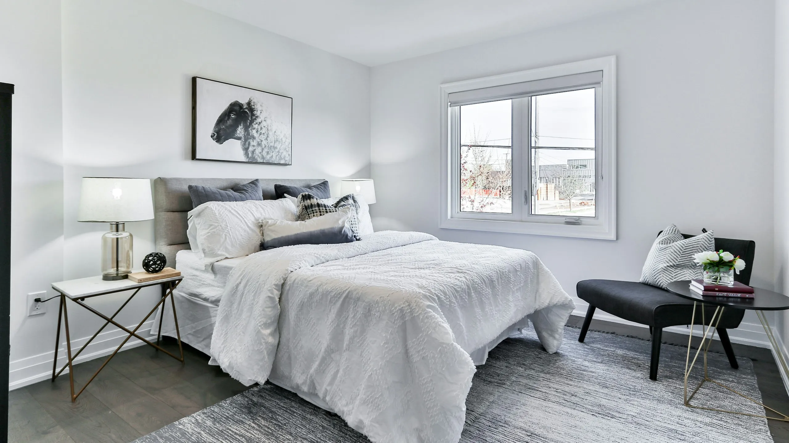 A made bed with white linen in a calm, bright bedroom