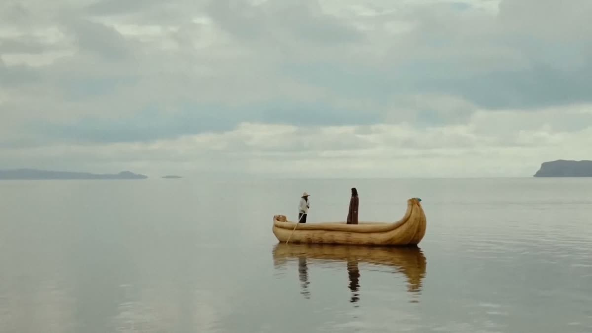 Two figures in a reed boat on a still lake