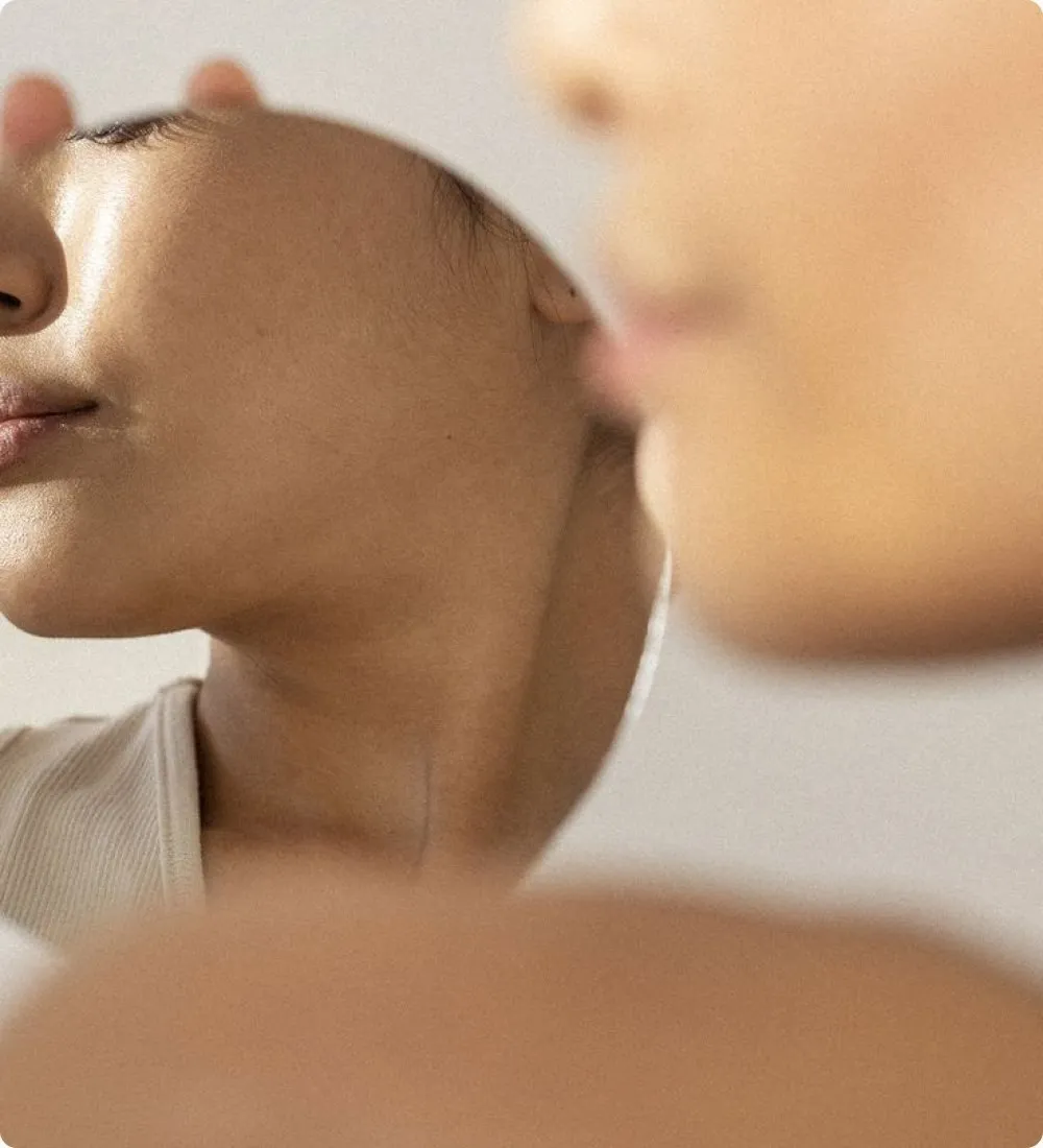 A woman looking into a hand mirror